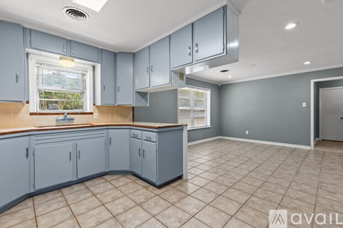 A kitchen with blue cabinets and a window.