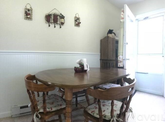 A dining room with a round wooden table and chairs.