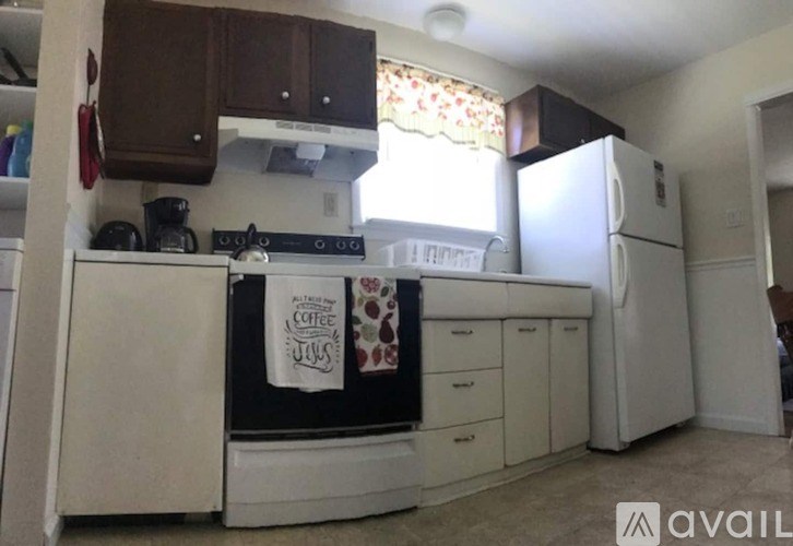 A kitchen with white appliances and a coffee sign on the fridge.