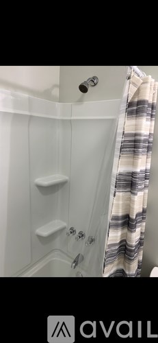 A shower with a striped shower curtain.