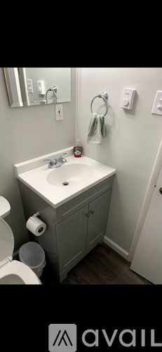 A bathroom with a white sink and a toilet.