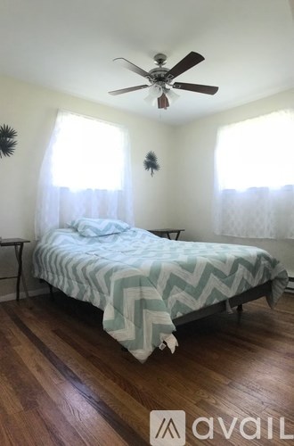A bedroom with a bed and a ceiling fan.