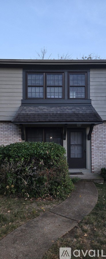 A house with a grey facade and a dark grey door.