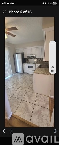 A kitchen with a refrigerator, microwave, and oven.