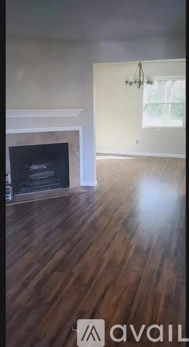 A room with a fireplace and wooden floors.