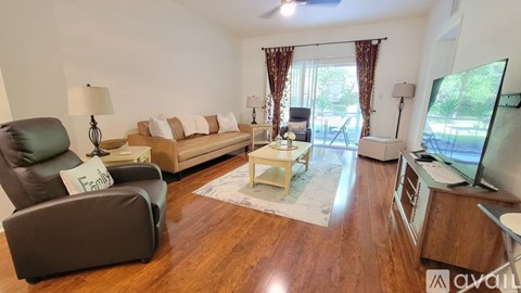 A living room with a brown sofa, a grey armchair, and a coffee table.