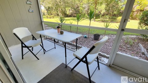 A patio with a table and chairs overlooking a garden.