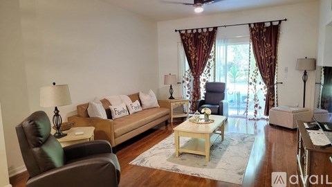 A living room with a brown leather chair and a white sofa with pillows.