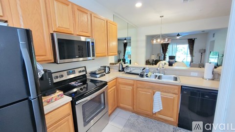 A kitchen with wooden cabinets and black appliances.
