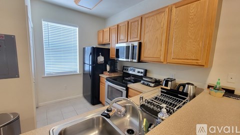 A kitchen with wooden cabinets and black appliances.