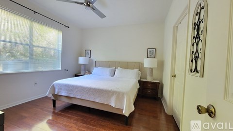 A bedroom with a bed, nightstand, and a ceiling fan.