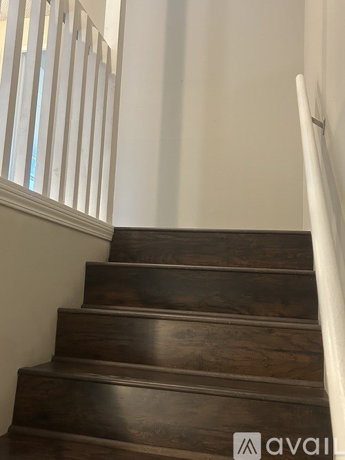 A wooden staircase with a white railing.