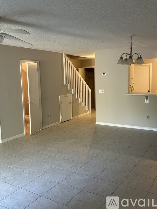 A room with a staircase and a ceiling fan.