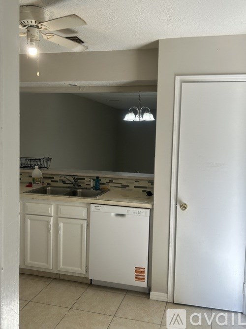 A kitchen with white appliances and cabinets.