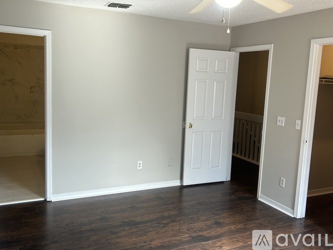A room with a white door and a fan on the ceiling.