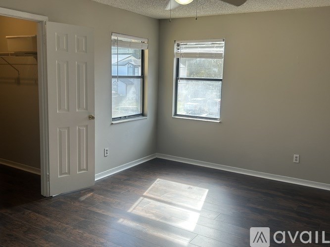 A room with a door and two windows.