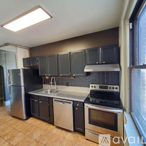 A kitchen with black cabinets and stainless steel appliances.