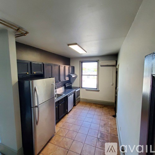 A kitchen with a refrigerator, microwave, and oven.