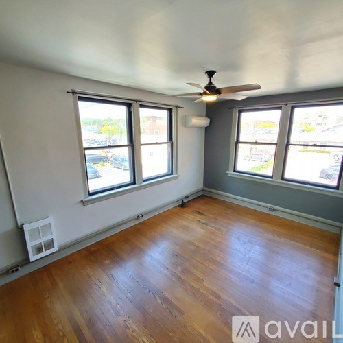 A room with wooden floors and a ceiling fan.