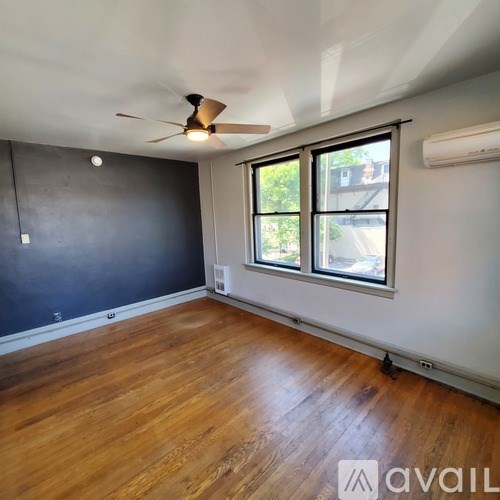 A room with a ceiling fan and wooden flooring.