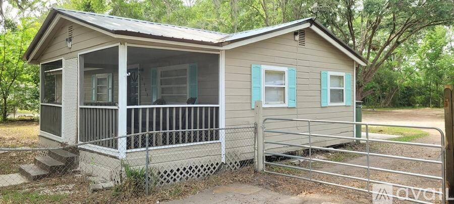 A small house with a porch and a fence.
