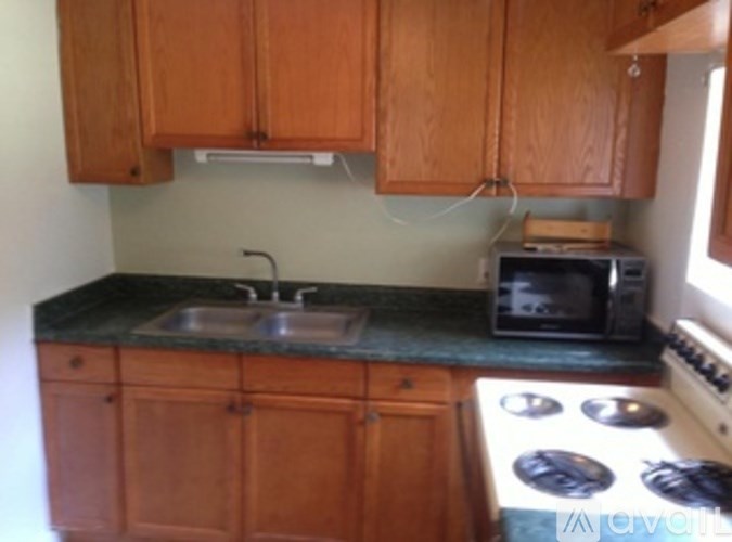 A kitchen with wooden cabinets and a black countertop.