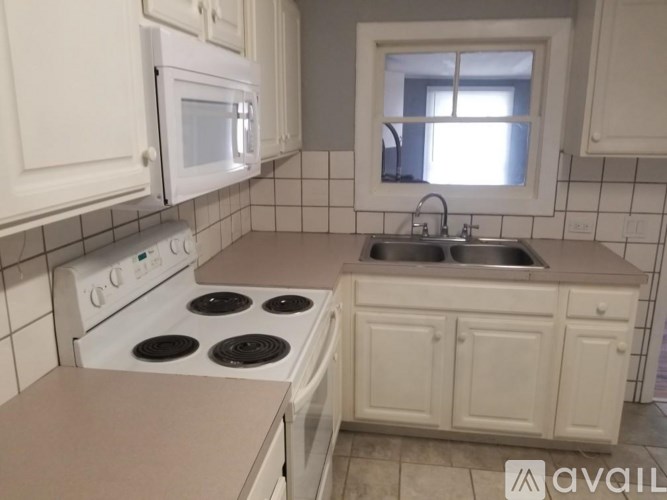 A kitchen with white appliances and cabinets.