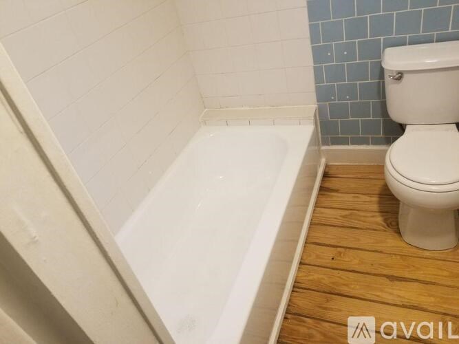 A white toilet sits next to a bathtub in a bathroom.