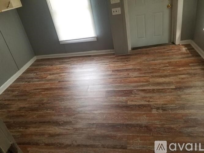 A room with wooden flooring and a white door.