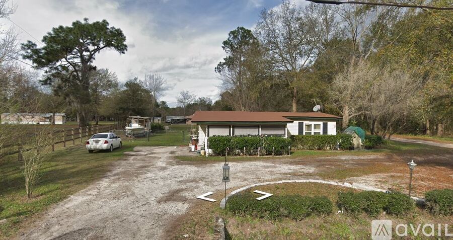 A house with a driveway and a car parked in front.