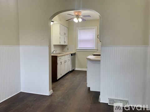 A kitchen with white cabinets and a window.