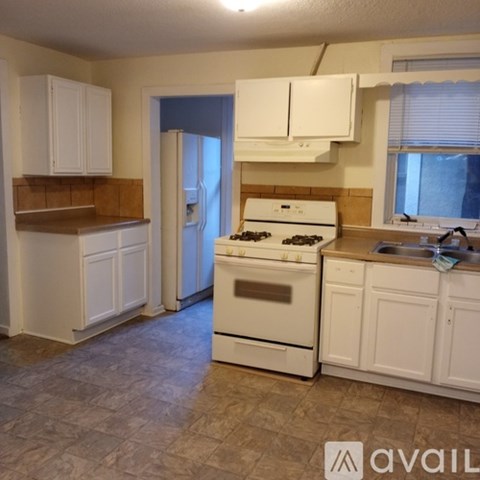 A kitchen with white cabinets and a stove top oven.