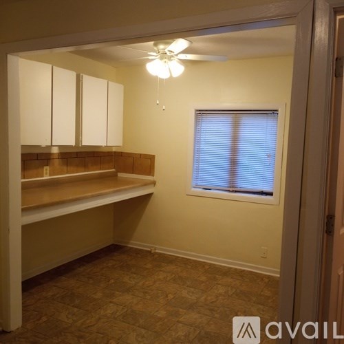 A room with a window and a fan.