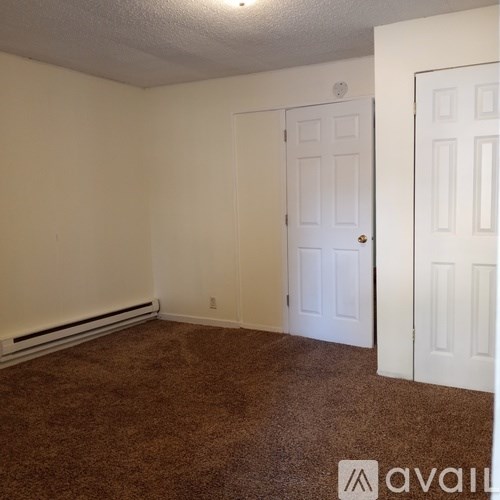 A room with brown carpet and white walls.