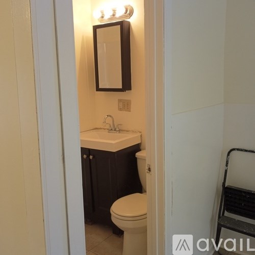 A bathroom with a toilet, sink, and mirror.