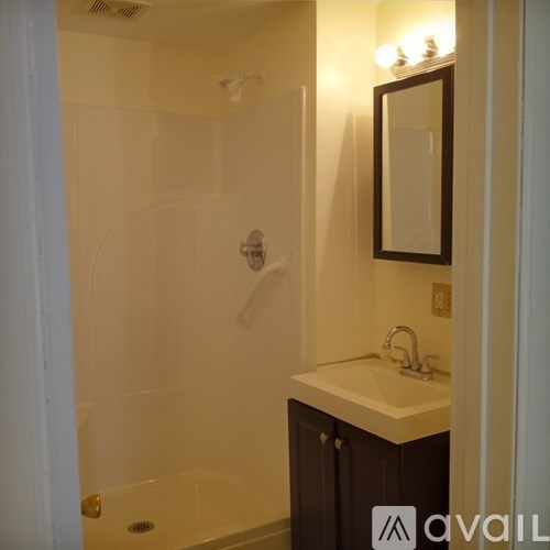A bathroom with a sink, mirror and shower.