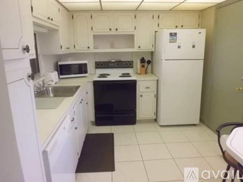 A kitchen with white cabinets and appliances.
