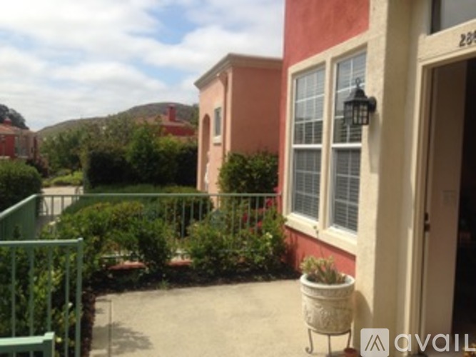 A house numbered 229 with a green fence and bushes in front.