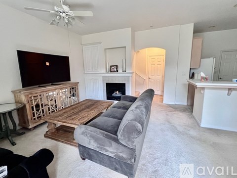 A living room with a grey couch and a wooden coffee table.