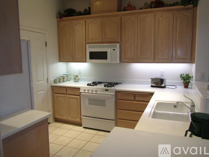 A kitchen with wooden cabinets and white appliances.