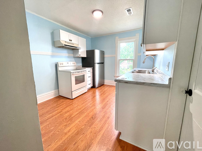 A kitchen with a refrigerator, oven, and microwave.