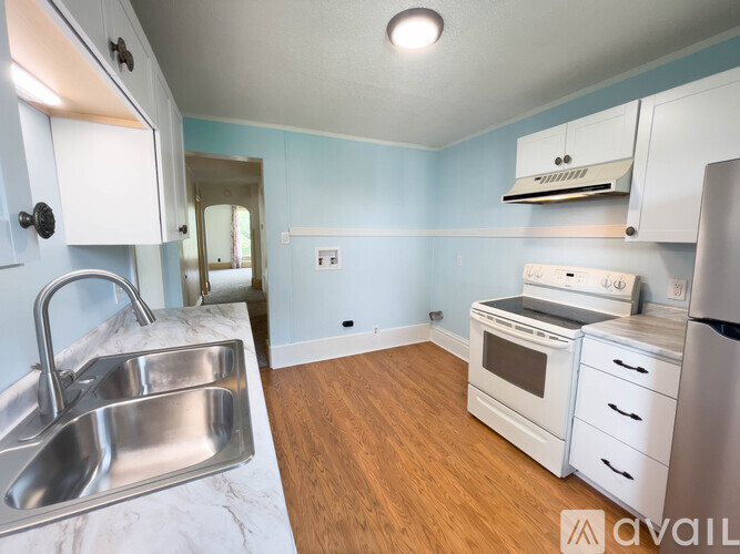A kitchen with a sink, stove, and refrigerator.