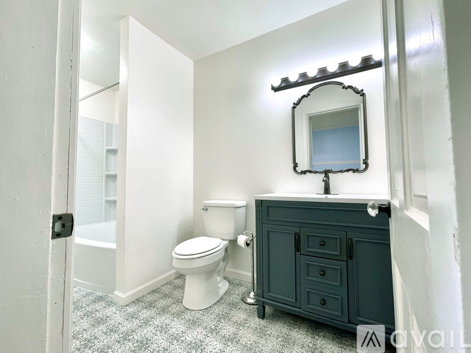 A bathroom with a toilet, sink, and mirror.