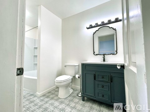 A bathroom with a toilet, sink, and mirror.