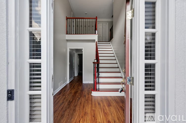 A white house with a red staircase.