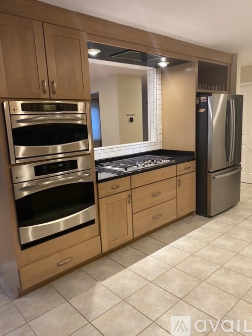 A kitchen with wooden cabinets and stainless steel appliances.