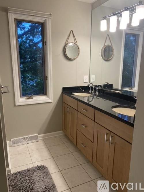 A bathroom with a sink, mirror, and a window.