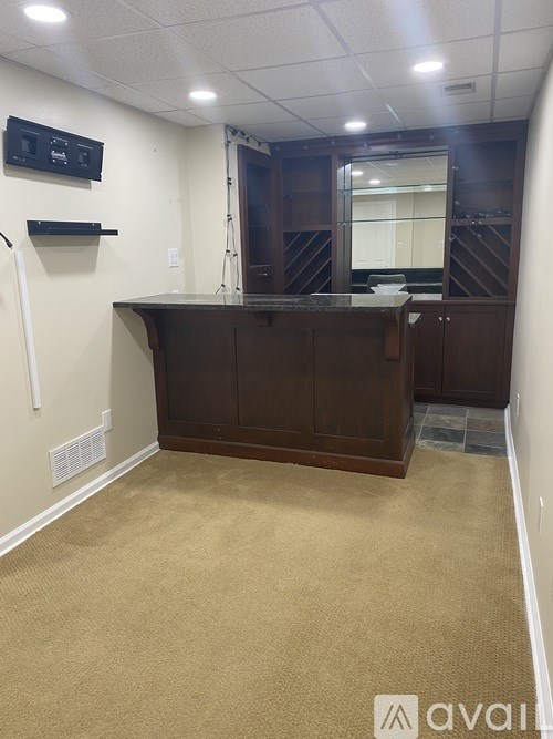 A reception area with a brown desk and a white wall.