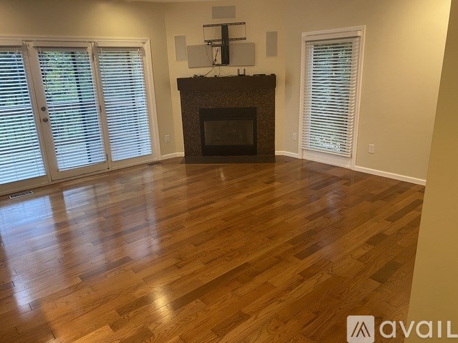 A living room with a fireplace and wooden floors.