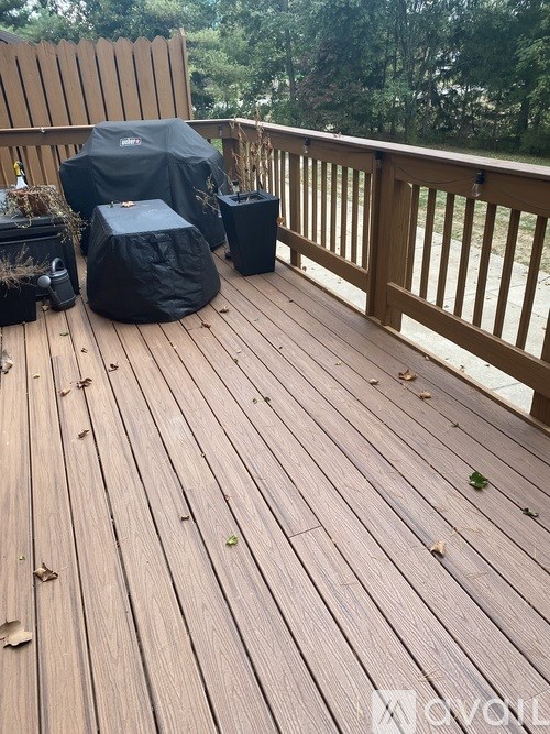 A wooden deck with a grill and cooler on it.
